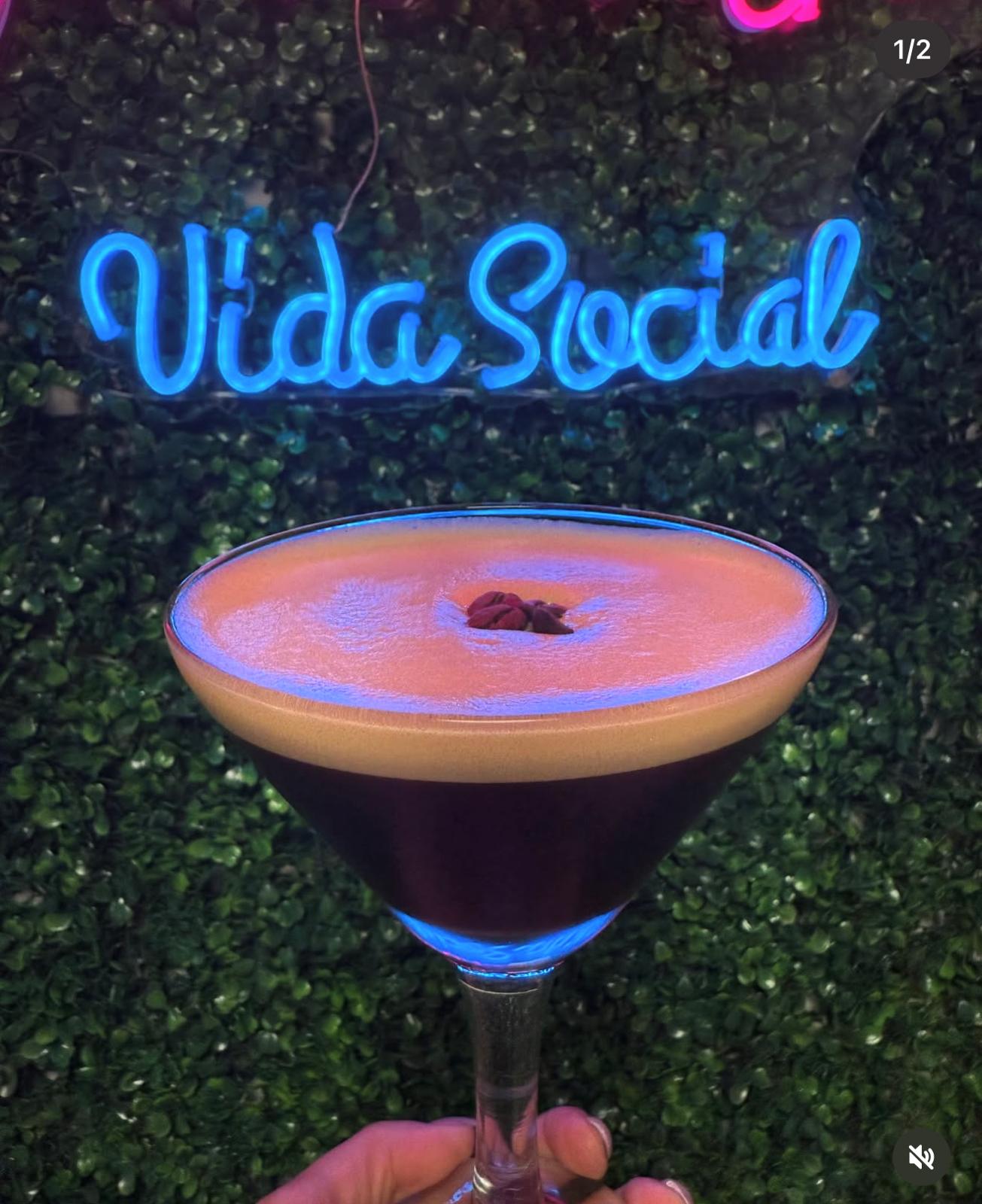 Coctel de la casa frente al letrero de neón de Vida Social